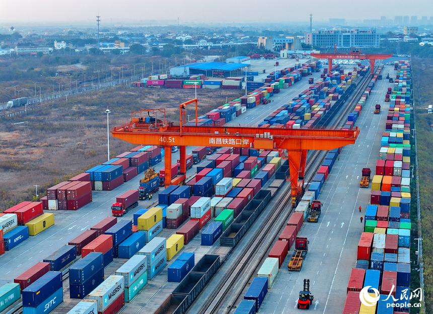 南昌国际陆港货运场站内，货物集装箱装卸有序进行，运输车辆往来穿行。人民网记者 朱海鹏摄