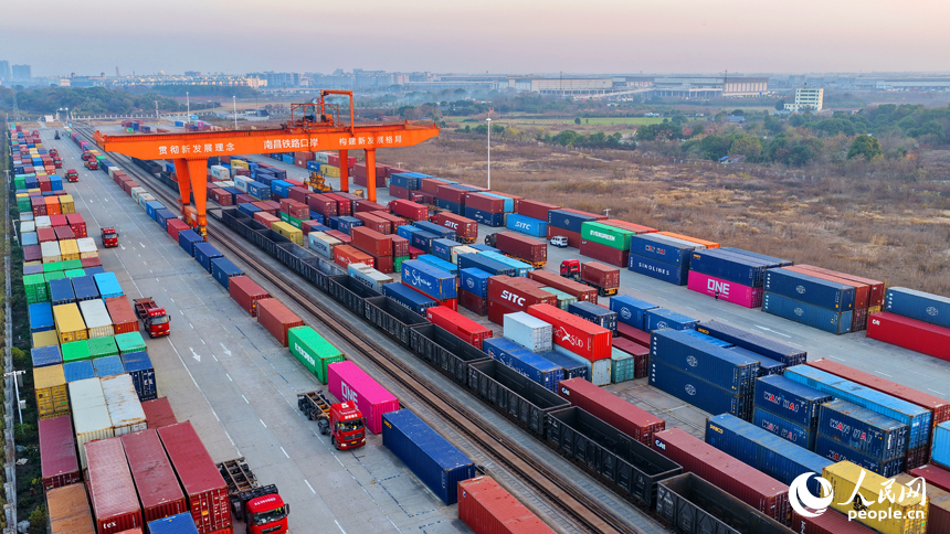 南昌国际陆港货运场站内，货物集装箱装卸有序进行，运输车辆往来穿行。人民网记者 朱海鹏摄