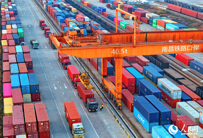 南昌国际陆港货运场站内，货物集装箱装卸有序进行，运输车辆往来穿行。人民网记者 朱海鹏摄