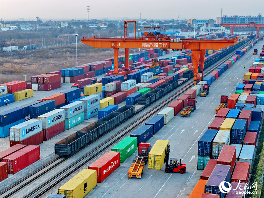 南昌國際陸港貨運場站內，貨物集裝箱裝卸有序進行，運輸車輛往來穿行。人民網記者 朱海鵬攝