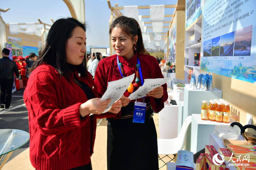 中国稀土集团展位前，定点帮扶县道孚县参展商正在介绍该县特色农产品。人民网记者 时雨摄