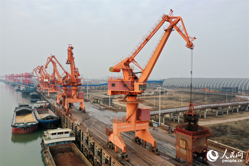 大型吊机正在卸载货船上的电煤、小麦等物资。人民网记者 时雨摄