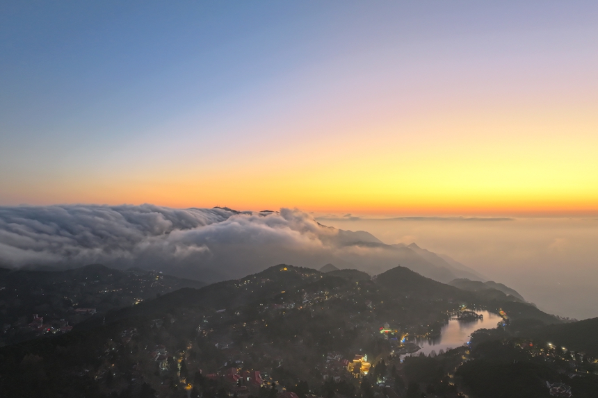 山脚下的如琴湖湖面平静如镜，倒映着漫天霞光与流动的云海。