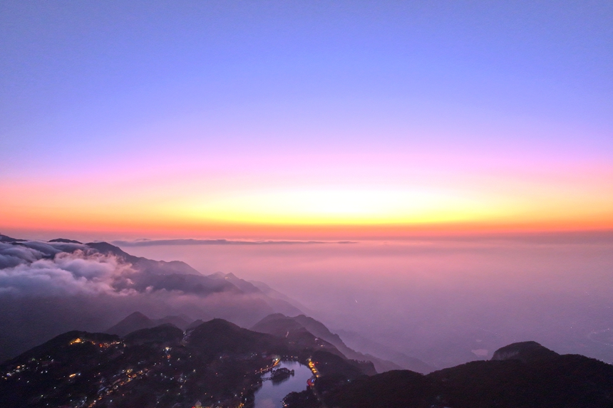 山脚下的如琴湖湖面平静如镜，倒映着漫天霞光与流动的云海。