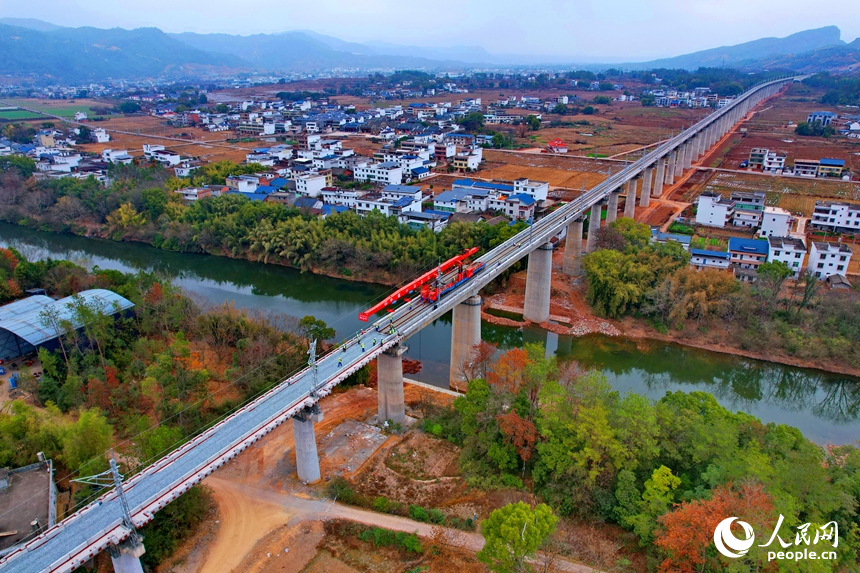 瑞金市謝坊鎮的瑞梅鐵路綿水特大橋施工現場，隨著最后一組25米軌排精准落在路基道床上，標志著瑞梅鐵路全線最長橋梁綿水特大橋順利完成鋪軌。人民網記者 朱海鵬攝