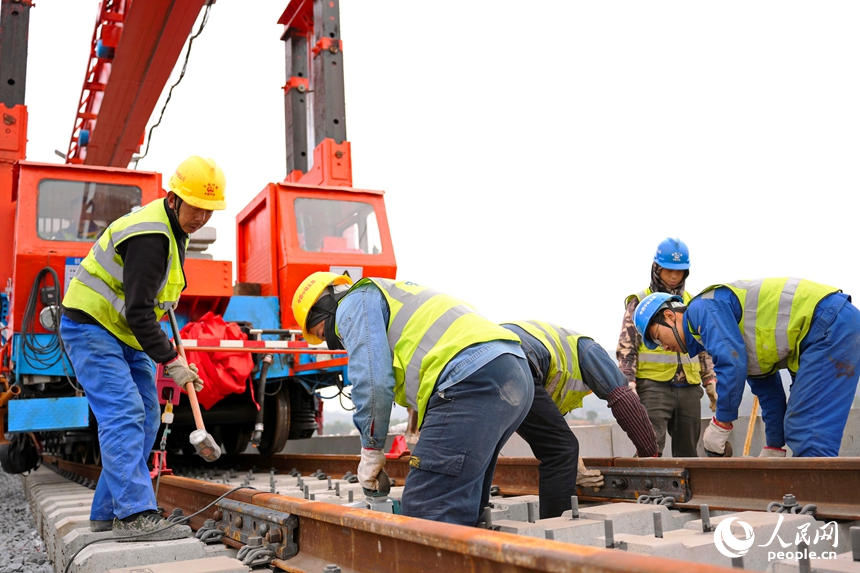 瑞金市謝坊鎮的瑞梅鐵路綿水特大橋施工現場，隨著最后一組25米軌排精准落在路基道床上，標志著瑞梅鐵路全線最長橋梁綿水特大橋順利完成鋪軌。人民網記者 朱海鵬攝