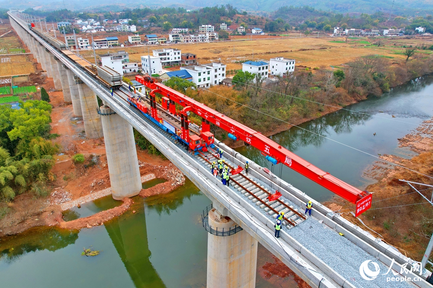 瑞金市谢坊镇的瑞梅铁路绵水特大桥施工现场，随着最后一组25米轨排精准落在路基道床上，标志着瑞梅铁路全线最长桥梁绵水特大桥顺利完成铺轨。人民网记者 朱海鹏摄