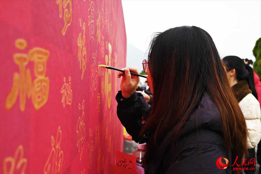 市民游客在“馬上有福”納福牆前揮毫寫“福”。人民網記者 黃睿靖攝