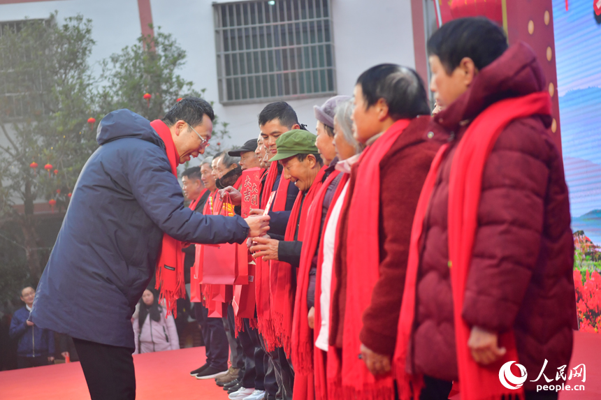 “村”晚现场举行神山村2025年度合作社分红仪式，合作社负责人给村民代表发放分红。人民网记者 时雨摄