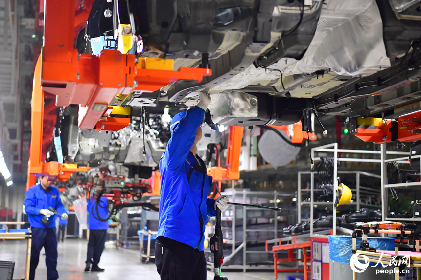 技術人員在底盤線工位進行底盤裝配操作。人民網記者 毛思遠攝