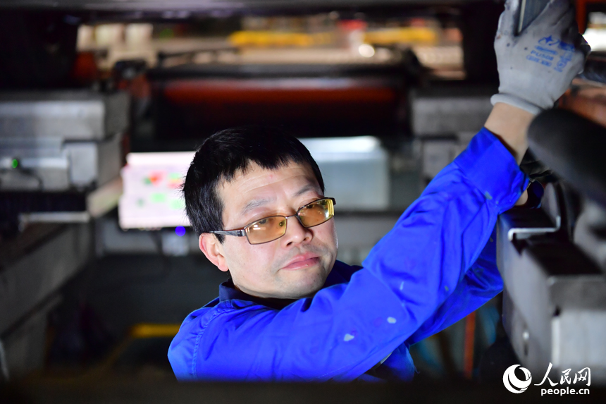 技术人员紧盯数据终端，对新车进行四轮定位检测与调整。人民网记者 毛思远摄