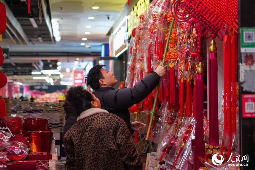 市民在年货店内精心挑选新春装饰。 人民网 涂诗轩摄