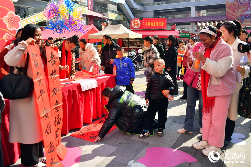 新洪城大市场内，留学生展示对联。人民网记者 时雨摄