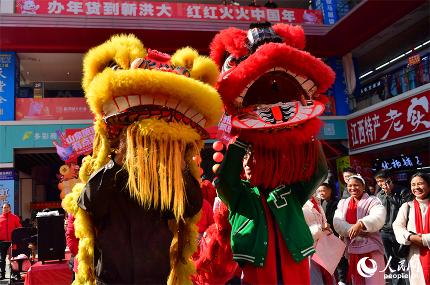 新洪城大市场内，留学生体验舞狮。人民网记者 时雨摄
