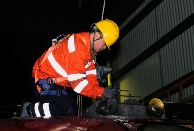 南昌机务段整备车间职工对入库机车顶部进行除冰作业。