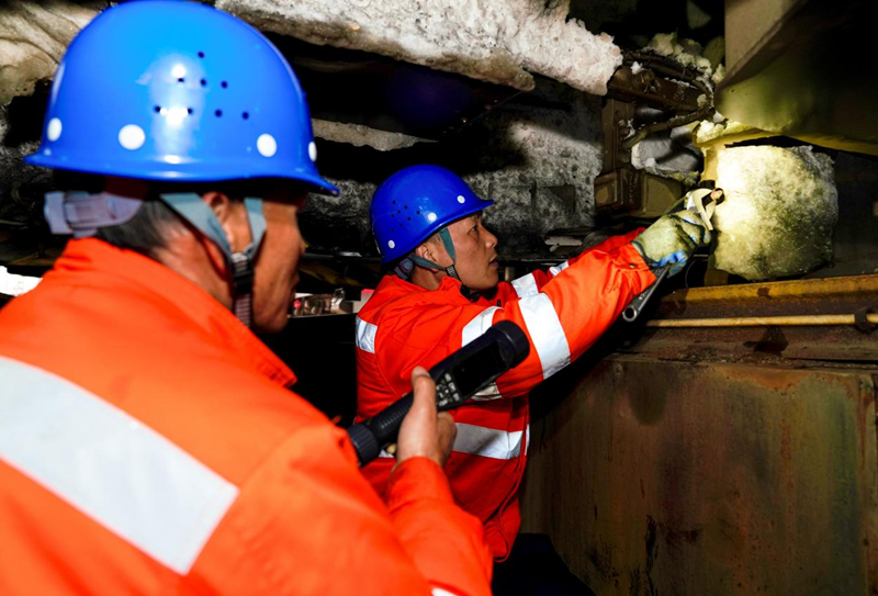 南昌机务段整备车间职工对机车走行部进行检修。