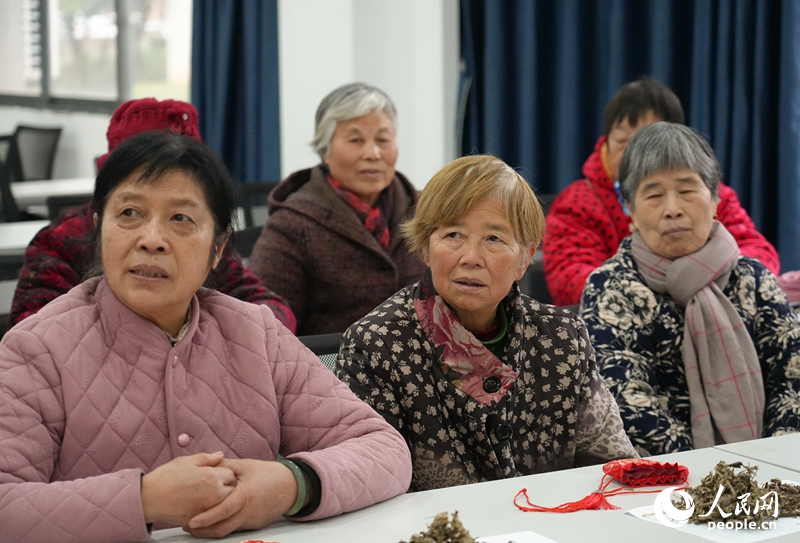 社区老人们认真聆听医生讲解新春养生知识。 人民网 黄睿靖摄