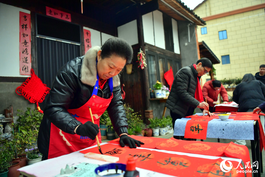 江西省南昌县塔城乡湖陂村洋溢着新春的氛围，书法家们在村中为村民们写春联。人民网记者 时雨摄