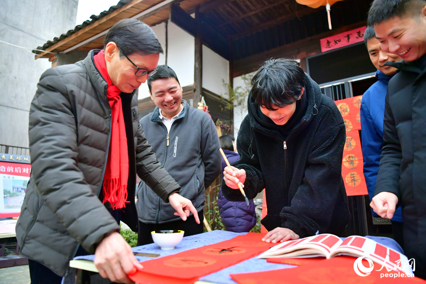 書法家教游客用毛筆寫春聯。人民網記者 時雨攝