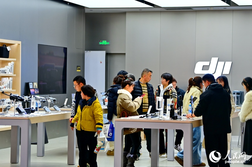 南昌市紅谷灘區的一家大型商業綜合體內，消費者在門店選購數碼和智能產品。人民網記者 朱海鵬攝