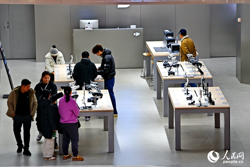 南昌市紅谷灘區的一家大型商業綜合體內，消費者在門店選購數碼和智能產品。人民網記者 朱海鵬攝