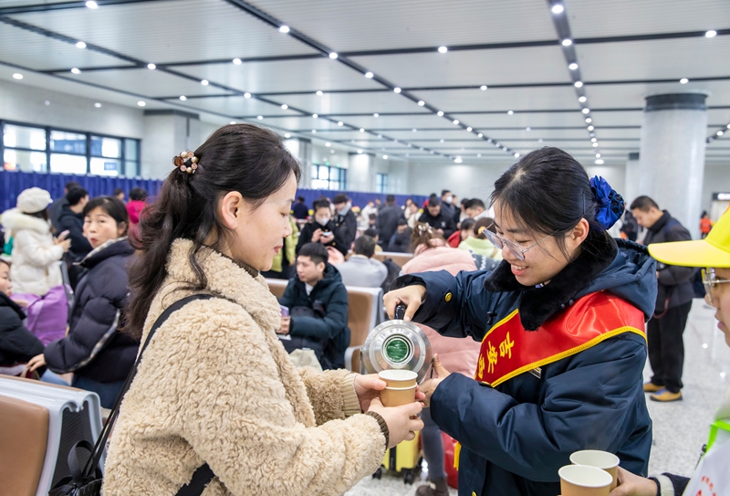 工作人員為務工旅客提供熱水服務。鄒陽攝