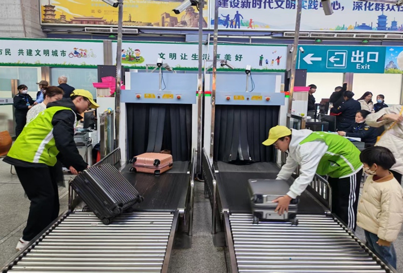 志願者幫助旅客搬運行李。胡尋風攝