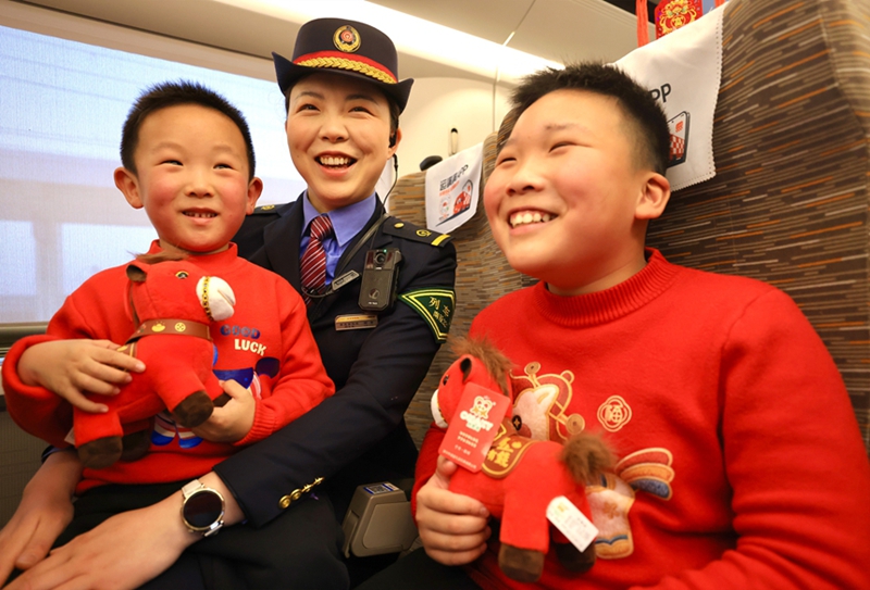 图为列车工作人员与儿童旅客互动。王超摄