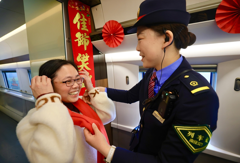 图为列车工作人员为旅客献上围巾。王超摄