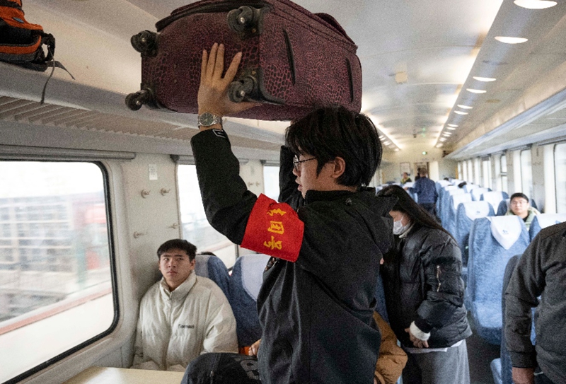 圖為青年乘務員協助旅客放置行李。朱仕煒攝