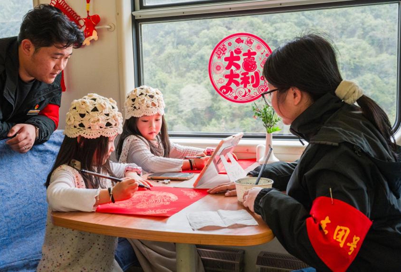 图为青年乘务员与双胞胎姐妹互动绘画马年创意画。朱仕炜摄
