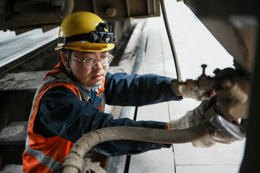 檢修人員緊固機車底部砂管部件螺栓。呂俊潔攝
