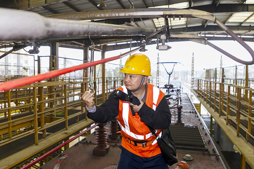 作業人員在檢測機車受電弓壓力。劉東攝