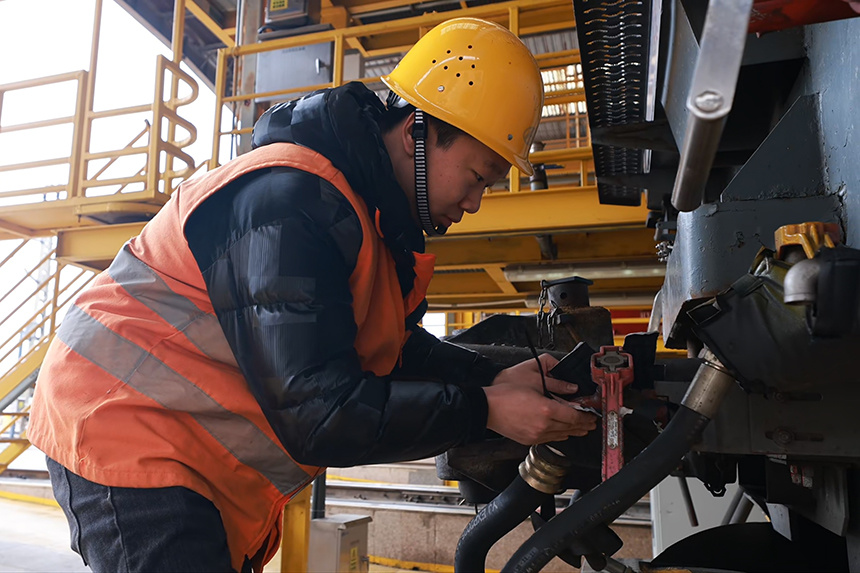 作業人員在防寒包扎機車外露管路。劉東攝