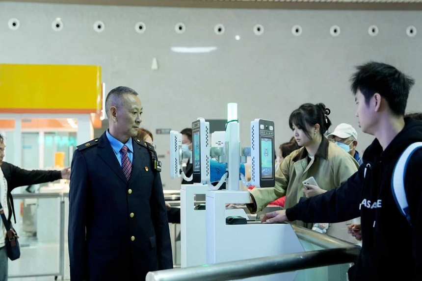 胡丹帮助旅客刷证进站。代建力摄