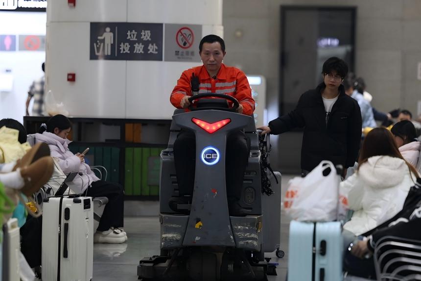 万武辉对候车大厅进行清扫。陈平摄