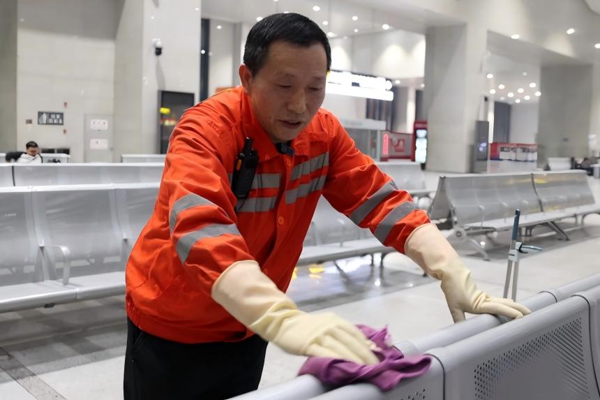 万武辉清洁候车区旅客座椅。陈平摄