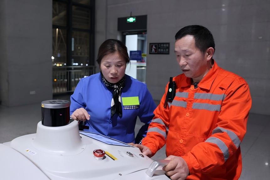 万武辉与万燕兰操作智能扫地机器人。贾瑞琛摄