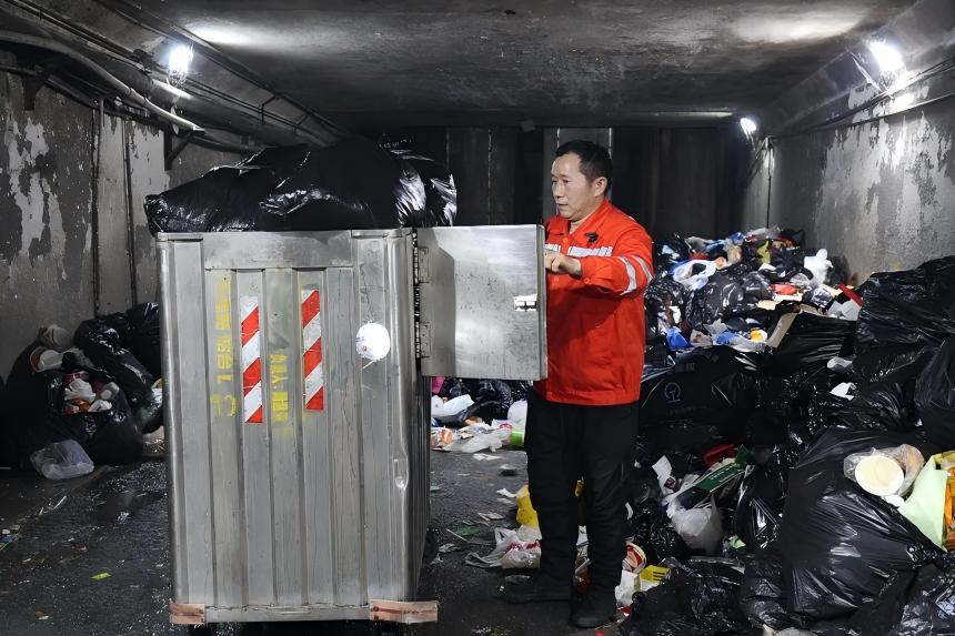 万武辉在垃圾投放点清理垃圾车。贾瑞琛摄