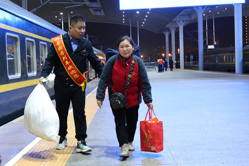 列车工作人员在帮助旅客乘降。 李婉秋摄