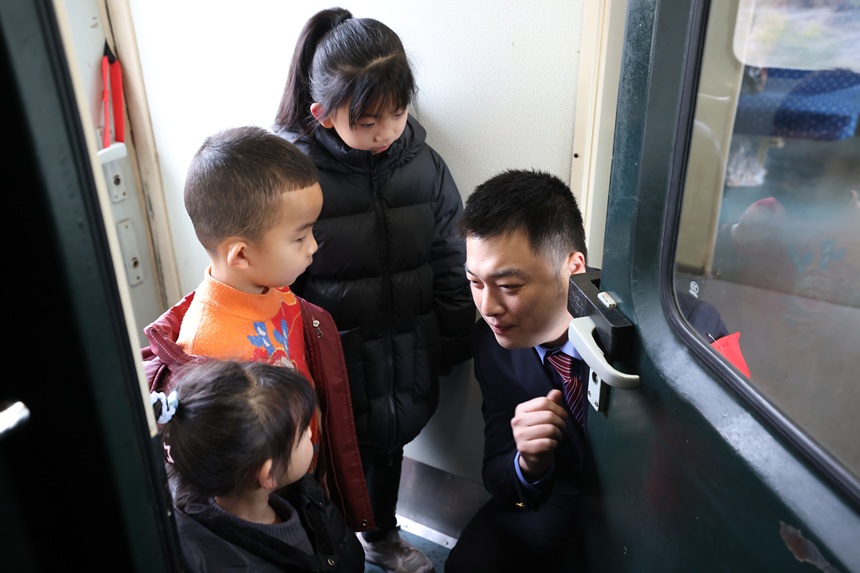列车工作人员与小朋友互动。 李婉秋摄