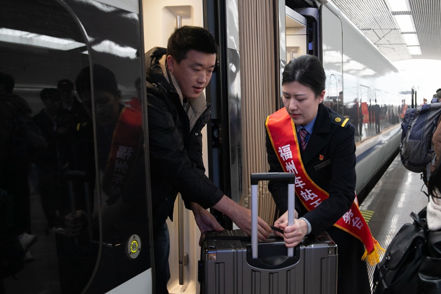 車站工作人員協助務工旅客下車。賴嘯雲攝