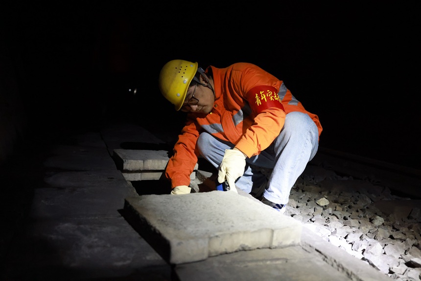橋隧工在檢查隧道排水溝。寇清清攝