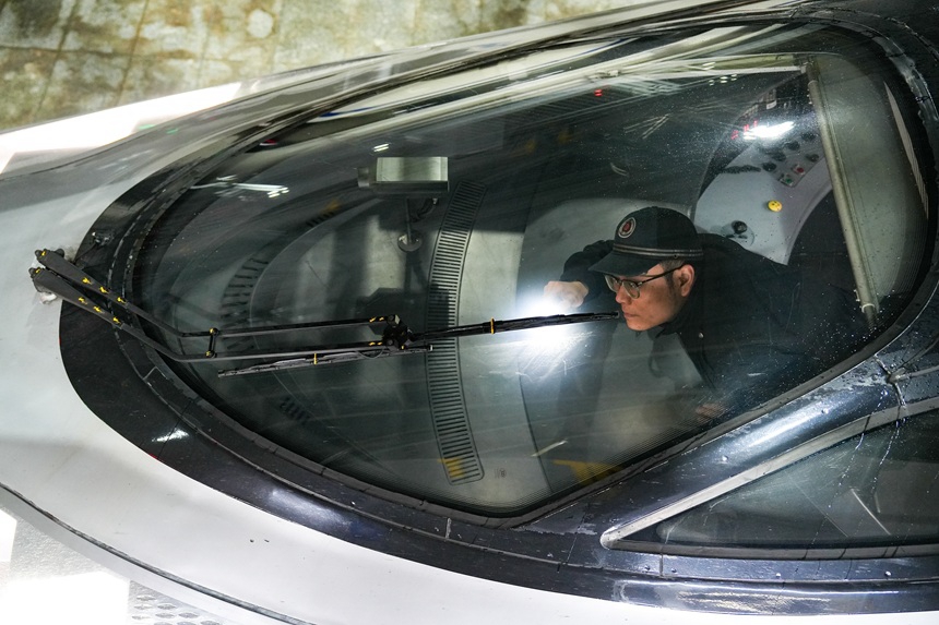 動車組機械師在檢查動車組雨刮器。譚文卿攝