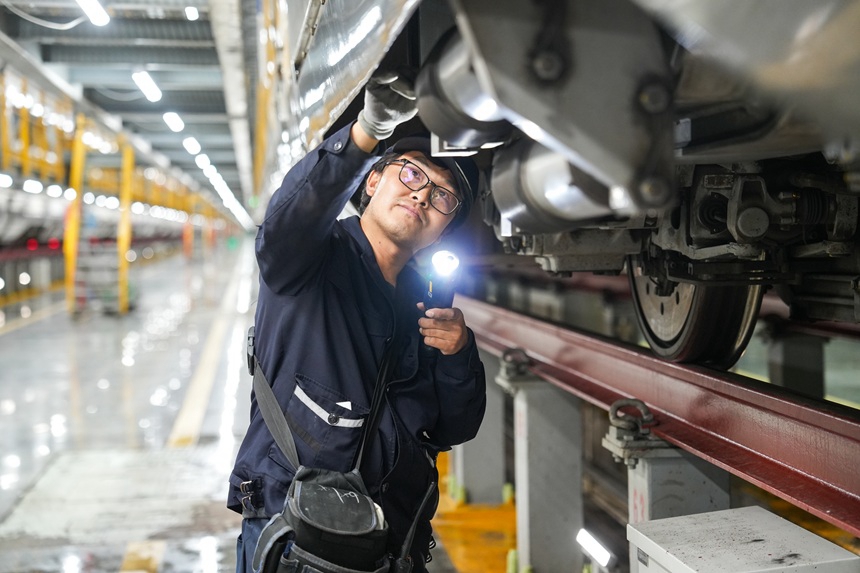 動車組機械師在檢查動車組走行部。譚文卿攝