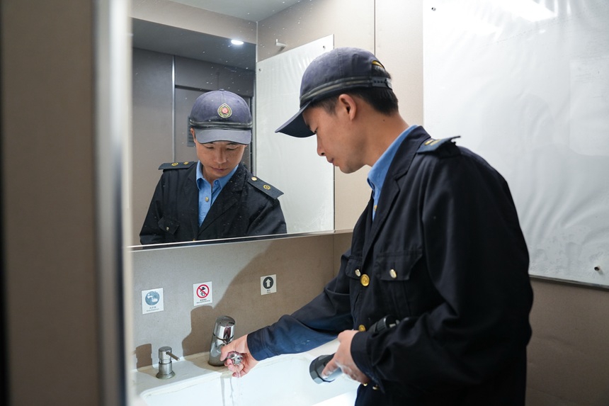 動車組機械師在檢查動車組水龍頭。譚文卿攝