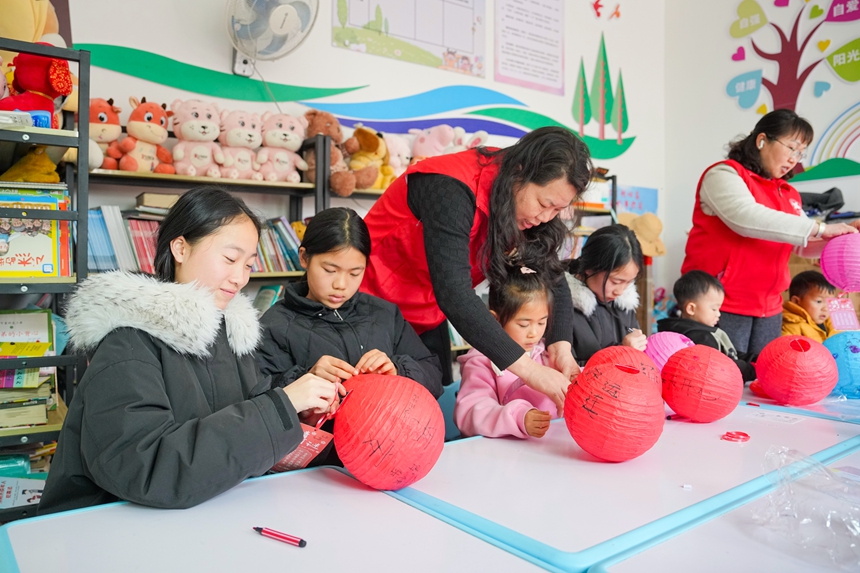 志願者和孩子們一起制作花燈。