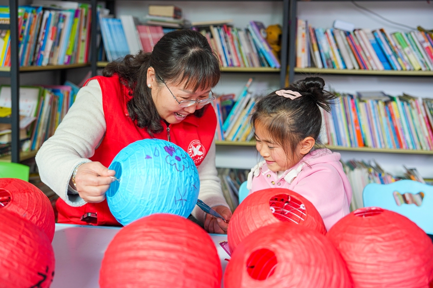 志願者和孩子們一起制作花燈。