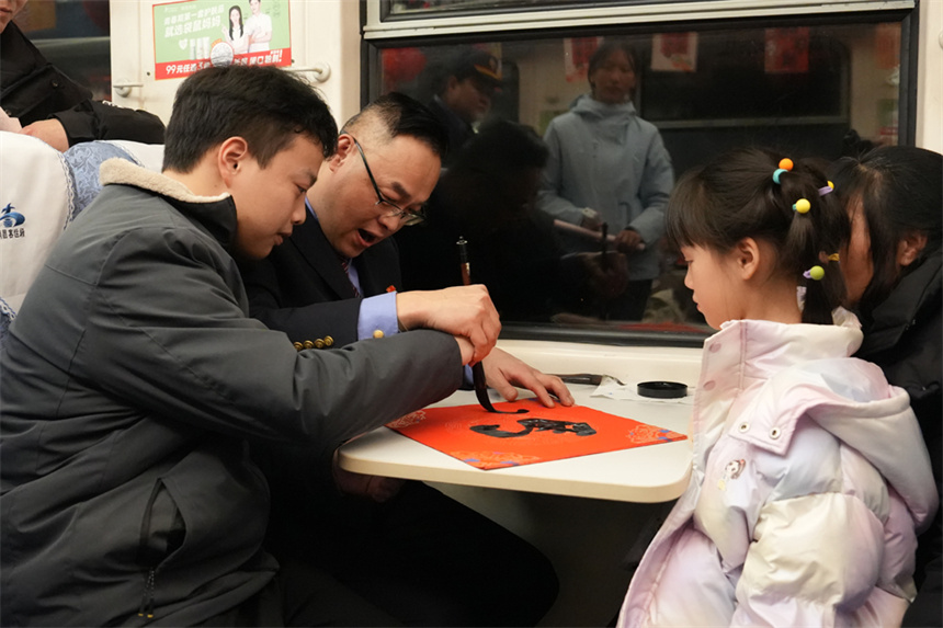 列車工作人員與旅客一起寫馬年祝福。王夢婧子攝