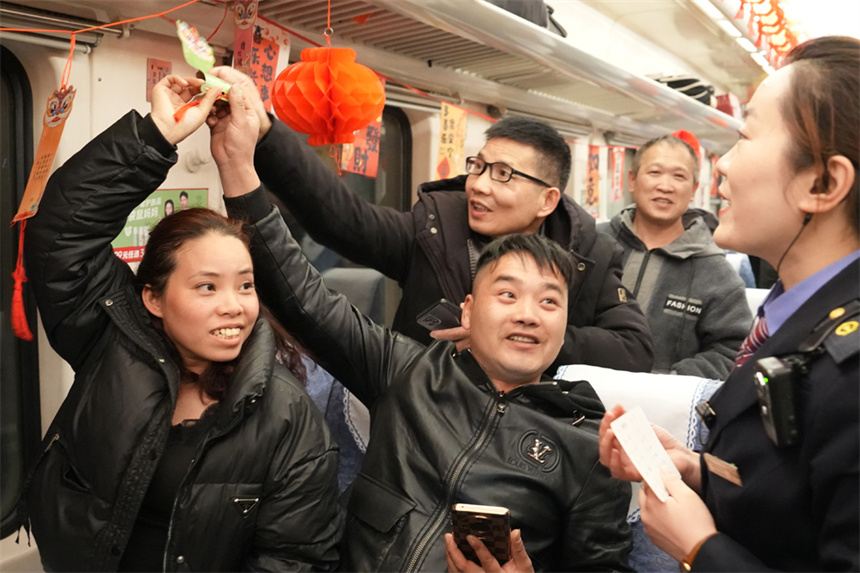 車廂裡，旅客正參與猜“燈謎”活動。 王夢婧子攝